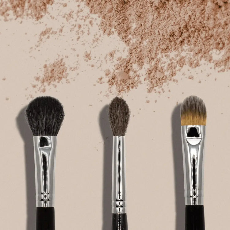 Three makeup brushes with powder, essential for premium skincare routines from MIANIMED