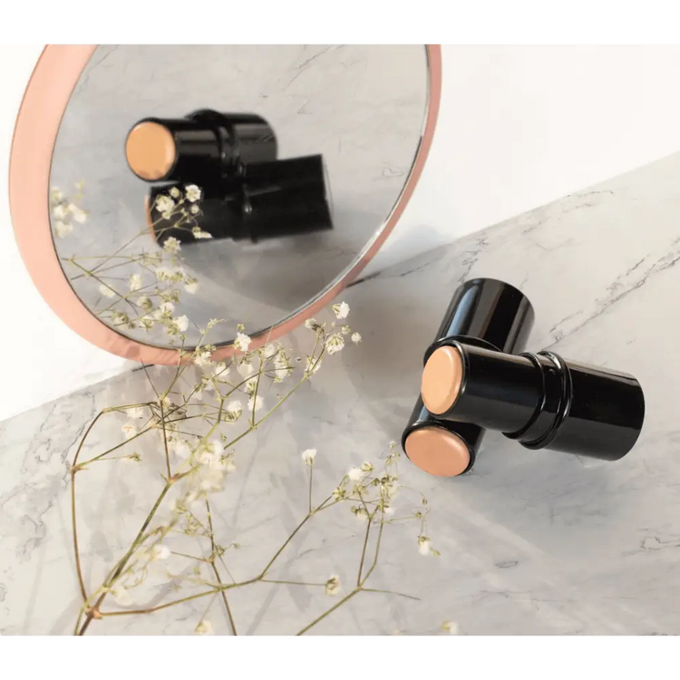 Premium MIANIMED skincare products reflected in a marble mirror with flowers.