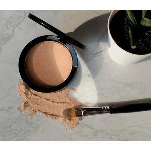 MIANIMED premium skincare powder and brush on marble surface next to a green plant